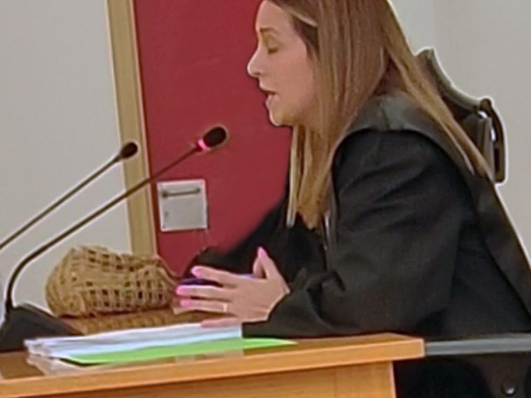 Abogada Ainhoa Sanz, con toga, hablando en un contexto judicial ante un micrófono.